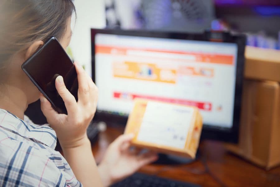 Telefonla konuşurken ekrandaki siparişi kontrol eden kişi